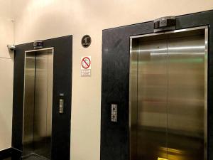 dois elevadores numa casa de banho pública com as portas abertas em Duplex Vintage en el corazón de Miraflores em Lima