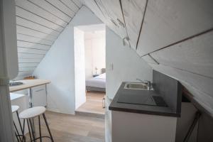 a kitchen with a sink and a room with a bed at Les Chambres de Lourmel in Pontivy