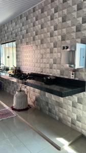 uma cozinha com uma bancada em azulejo e um micro-ondas em KasaNivea em Pirenópolis