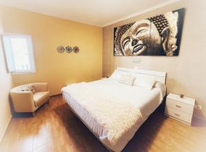 a bedroom with a bed and a painting on the wall at CASA ROSALÍA. APARTAMENTO CON VISTAS A LA MONTAÑA in Teror