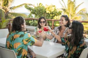 a group of people sitting around a table eating food at Casa Hayhu in Mahahual