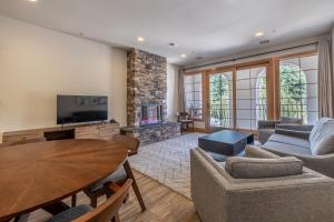 a living room with a table and a tv at Alpen Dorf Pension in Leavenworth