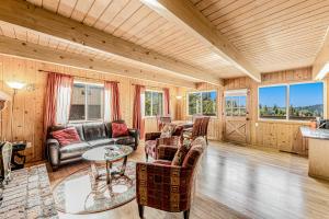 una sala de estar con paredes y muebles de madera y ventanas en Scenic Solitude, en Lake Arrowhead