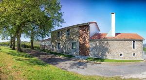 un edificio de ladrillo con una chimenea a un lado en A casa do viveiro, en Dormeá