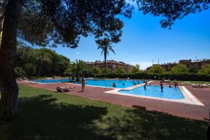 people playing in a swimming pool in a park at Camping Santa Elena in Lloret de Mar