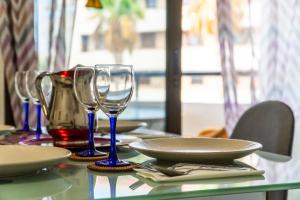 a table with two wine glasses and plates on it at SUMMERLAND SUNSET in Los Cristianos