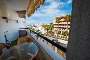 a balcony with a table and a view of a city at SUMMERLAND SUNSET in Los Cristianos