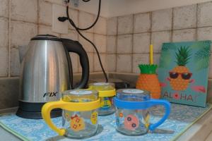 Pousada Recanto da Família في ناتال: كاونتر مطبخ مع غلاية شاي وثلاث أكواب