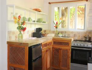 a kitchen with a counter with vases of flowers on it at Hotel Posada Arco Iris in Roatan