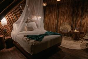 Schlafzimmer mit einem Bett mit Moskitonetz in der Unterkunft Casa Hayhu in Mahahual
