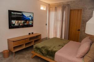 拉巴斯的住宿－MANGLITO MANILA，卧室配有一张床,墙上配有电视。
