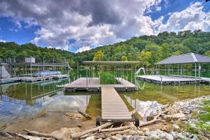 a dock in a body of water with trees at Caryville Home with Dock, Steps to Norris Lake! in Caryville