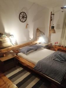 ein Schlafzimmer mit einem Holzbett und einer Uhr an der Wand in der Unterkunft Chostello Ecomis Rustik in Sibiu