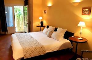 a bedroom with a white bed and a window at Auberge des Glycines in Porquerolles