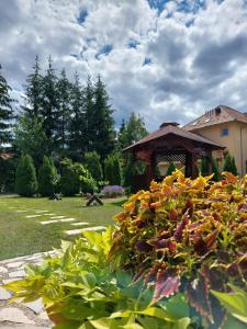 um jardim com um gazebo e algumas flores em Apartmani Nika em Zlatibor