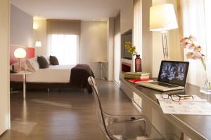 a bedroom with a bed and a desk with a laptop at Central Apartamentos Bogotá in Bogotá