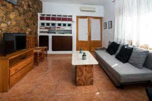 - un salon avec un canapé et une télévision dans l'établissement Casa Sagrario, à Santa María de los Llanos