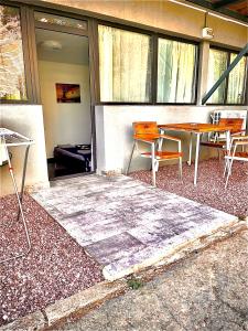 un patio con tavolo, sedie e finestre di Quantum villa a Neptun