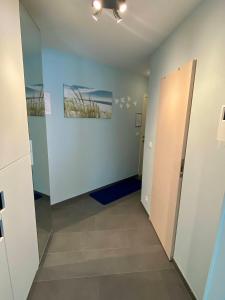 un couloir d'une chambre vide avec une porte dans l'établissement Even naar zee Nieuwpoort Appartement Waterkant, à Nieuport