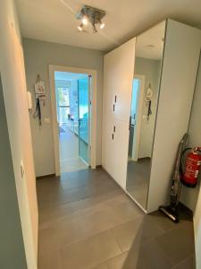un couloir avec un miroir et un couloir menant à une chambre dans l'établissement Even naar zee Nieuwpoort Appartement Waterkant, à Nieuport