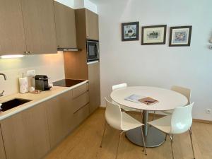 małą kuchnię ze stołem i krzesłami w pokoju w obiekcie Even naar zee Nieuwpoort Appartement Waterkant w mieście Nieuwpoort