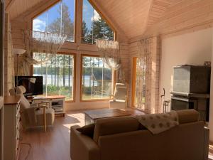 - un salon avec un canapé et quelques fenêtres dans l'établissement Villa Lilian, à Ähtäri
