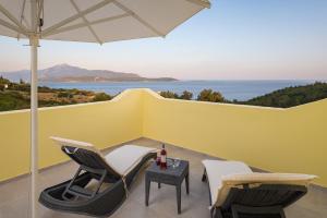 a patio with two chairs and a table with an umbrella at Naftilos in Pythagoreio