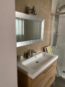 een badkamer met een witte wastafel en een spiegel bij Castle view in Alicante