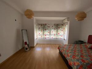 een slaapkamer met een bed en een raam met een gordijn bij Castle view in Alicante