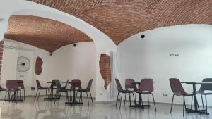 um quarto com cadeiras e mesas e um tecto de tijolos em Novara em Novara