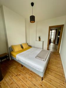 Bett in einem Zimmer mit Holzboden in der Unterkunft Bohemian 2BDR apartment Antwerp Center in Antwerpen