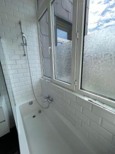 bagno con vasca e finestra di Bohemian 2BDR apartment Antwerp Center ad Anversa