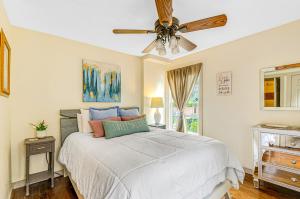 a bedroom with a bed with a ceiling fan at Taylor Cottage in Savannah