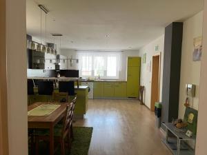 a kitchen and dining room with a table and green cabinets at Dom Melissa v malebnej obci Banka in Piešťany