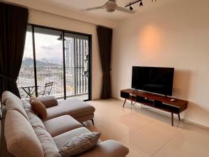 a living room with a couch and a flat screen tv at EkoCheras Residences by White Forest Suites in Kuala Lumpur