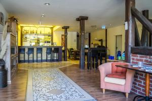een woonkamer met een bar en een roze stoel bij Hotel Garni FairSchlafen in Minden