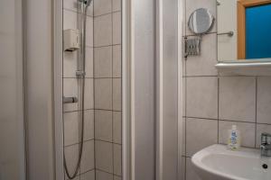een badkamer met een douche en een wastafel bij Hotel Garni FairSchlafen in Minden