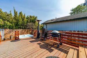 a wooden deck with a grill and a fence at Serenity By The Sea in McKinleyville