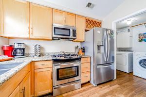 una cocina con armarios de madera y electrodomésticos de acero inoxidable en Serenity By The Sea en McKinleyville