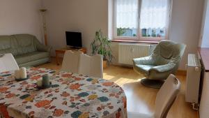 een woonkamer met een tafel en stoelen en een bank bij Roter Milan in Kaisitz