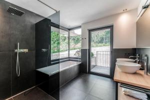 uma casa de banho com uma banheira, um lavatório e um chuveiro em Culinaria living em Tirolo