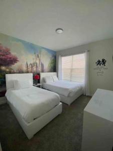 a bedroom with two beds and a painting on the wall at Villa, private pool, water park, Orlando parks in Kissimmee