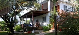 a white house with a porch and a patio at BlueBelize B&B in Punta Gorda
