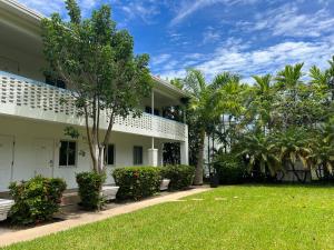 a white house with a lawn and palm trees at Beach Gardens in Fort Lauderdale