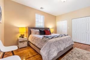 a bedroom with a bed and a chair and a window at Cozy Historic 2BR House 10 Min to French Quarter in New Orleans