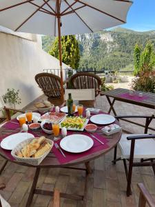 una mesa de picnic con comida y bebida y una sombrilla en al-qandil en Margarida