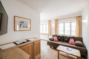 Una sala de estar con un sofá y dos ventanas. en Residence Villa Maria, en Sesto