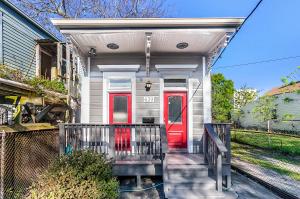 eine rote Tür auf einem Haus mit einer Veranda in der Unterkunft Spacious Historic Mid-City 2 Bedroom House!!! in New Orleans