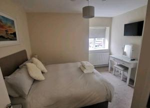 a bedroom with a bed and a desk and a television at Griffin 2 Apartments in Nottage
