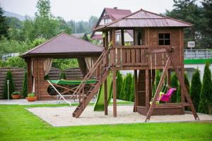 a playground with a play house and a slide at Zielona willa in Rabka-Zdrój